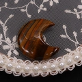 Detailed macro shot of polished crescent moon tiger eye stone on elegant lace background - 25x30mm, 8mm Thickness / Tiger's Eye
