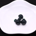 Detailed macro view of three green mushroom stones with drilled holes on a white plate - Glossy Deep Green