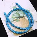 Macro detail of blue bone-shaped synthetic turquoise beads with natural dark veins for DIY jewelry - Sky Blue