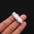 Miniature white turquoise hexagonal prism crystal point held between fingers - 8x33mm / Howlite