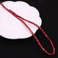 Macro detail of red stone tube beads with natural texture on a white decorative plate - 4x8mm / Reddish Brown (1)