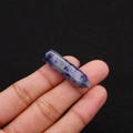 Macro detail of a polished hexagonal sodalite crystal pillar held between fingers - 8x33mm / Blue Spot Stone