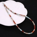 Detailed macro view of 4x8mm imperial stone beads on a decorative white ceramic plate - 4x8mm / Red Blue Mixed (No.10)