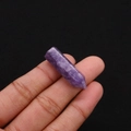 Macro view of natural purple amethyst crystal hexagonal column held between fingers - 8x33mm / Phosphosiderite