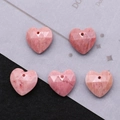Detailed macro view of five faceted pink heart stone pendants for DIY necklace jewelry - Rhodonite