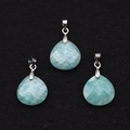 Detailed macro view of three faceted Amazonite teardrop pendants on black velvet background - Amazonite