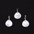 Detailed macro of three white howlite teardrop pendants with marble texture and silver bails - Howlite