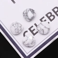 Macro detail van vier hartvormige witte turkoois edelstenen met grijze texturen - Howliet