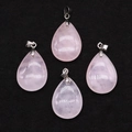 Detail of four pink quartz teardrop pendants with silver clasps on black velvet surface - 18x25mm / Rose Quartz