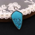 Vue détaillée d'un pendentif en turquoise en forme de flèche avec une bordure dorée - Turquoise Bleue