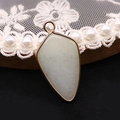Détail d'un pendentif en pierre naturelle vert clair en forme de bouclier avec bordure dorée - Light Green Agate