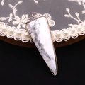 Detalle del colgante triangular de piedra jaspeada con borde de metal chapado en oro - 16x46mm / Howlita