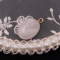 Dettaglio macro del ciondolo ovale in quarzo rosa sfaccettato con anello in metallo oro - Quarzo rosa
