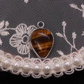 Detail of waterdrop tiger eye pendant with silver frame on vintage lace and pearl decor - Tiger's Eye