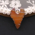 Detail van gestreepte agaat hanger met gouden metalen frame met gegroefde randen - Oranje Wit (Nr.8)