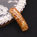 Macro shot of curved natural stone pendant connector with reddish-brown marble texture - Cream Red Brown Spotted (No. 6)