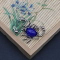 Detalle de colgante de escorpión con piedra azul sobre un fondo de estera de bambú - Forma de Escorpión (1065-T250515005) / Resina de Gema Azul