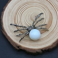 Detailansicht eines Vintage-Spinne-Anhängers mit Perle auf einem runden Holzständer - 34x47mm / Weiß (Nr. 1)
