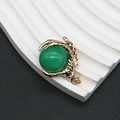 Primer plano del colgante de garra de dragón dorada con una cuenta de piedra verde - 25x31mm, 15g / Jade Verde