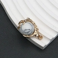 Detalle macro del colgante de garra de dragón dorado con piedra blanca para joyería DIY - 25x31mm, 15g / Howlita