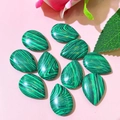 Macro view of teardrop malachite stones showing natural green banded texture - 17x24mm / Malachite