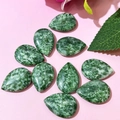 Macro detail of ten teardrop-shaped green agate stones on a pink background - 17x24mm / Green Spotted Stone