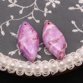 Primer plano de colgantes marquesa de piedra púrpura con vetas rojas sobre encaje blanco - No. 30