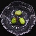 Primer plano de tres piedras turquesas ovaladas con vetas marrones naturales en un bol de vidrio - Verde Esmeralda (No. 8) / 13x18mm