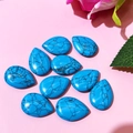 Flat lay of ten teardrop-shaped turquoise stones with black matrix texture for DIY jewelry - 17x24mm / Dark Blue Turquoise