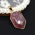 Macro shot of faceted pink crystal gemstone pendant with gold-plated edge on lace - Watermelon Quartz