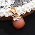 Makro-Detail des eichelförmigen rosa Quarz-Anhängers mit polierter Gold-Metallkappe - Rosa Eichel (Nr. 9)