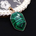 Detailed view of faceted malachite stone shield pendant with gold plated edges on black lace - Malachite