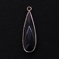 Macro view of faceted black stone drop pendant with gold-plated metal border - 11x41mm / Black Agate