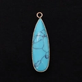 Macro detail of teardrop turquoise pendant with elegant gold plated rim and top loop - 11x41mm / Blue Turquoise
