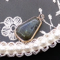 Dettaglio del ciondolo in labradorite sfaccettata con cornice dorata su pizzo e perle - Pietra Flash (Labradorite)