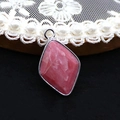 Macro shot of rhombus rhodochrosite pendant with silver metal border and pink texture - Rhodonite