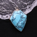 Macro shot of turquoise stone pendant with gold plated rim and black spiderweb texture - Blue Turquoise