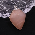Macro detail of a rose quartz shield pendant with faceted cut and gold plated metal edge - Pink Aventurine