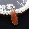 Macro-opname van druppelvormige natuursteen hanger met gouden plating voor sieraden - 12x36mm / Maat 16