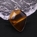 Macro shot of tiger eye stone pendant showing golden luster and metal border - Tiger's Eye