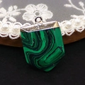 Sword-shaped malachite patterned stone pendant with golden metal bail on black background - 20x30mm / Malachite