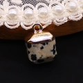 Macro shot of square Dalmatian jasper stone pendant with gold-plated metal cap details - 10x15mm / Dalmatian Jasper