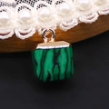 Macro detail of a square green malachite stone pendant with a gold plated metal loop - 10x15mm / Malachite