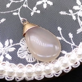 Detail shot of a white water drop stone pendant with gold clasp on white lace and pearls - 20x35mm / Milky White (No.2)