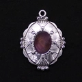 Makroaufnahme: Silberner ovaler Anhänger mit lila Stein und geprägtem Vintage-Muster - Amethyst