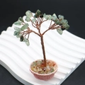 Gros plan d'un arbre en fil de cuivre avec feuilles de pierres vertes sur support blanc - Prehnite