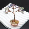 Gros plan d'un arbre de vie artisanal en fil de cuivre avec éclats de pierres précieuses - Fluorite violette