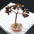 Vue macro de l'arbre de cristal œil de tigre avec fil de cuivre sur support ondulé blanc - Œil de tigre