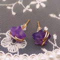 Dettaglio macro di orecchini a stella in ametista viola con filo dorato e pizzo bianco - Ametista