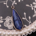 Détail d'un pendentif en lapis-lazuli en forme de goutte avec bordure dorée - Lapis-lazuli